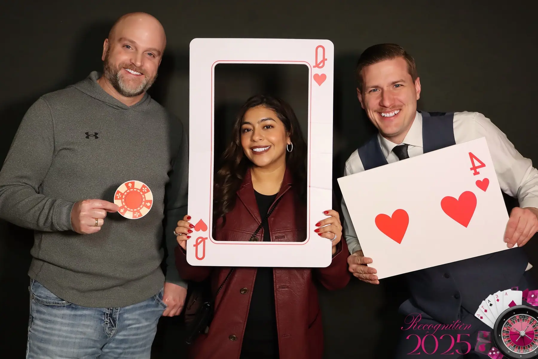 Three corporate-event guests posing with casino props by Images & Creations