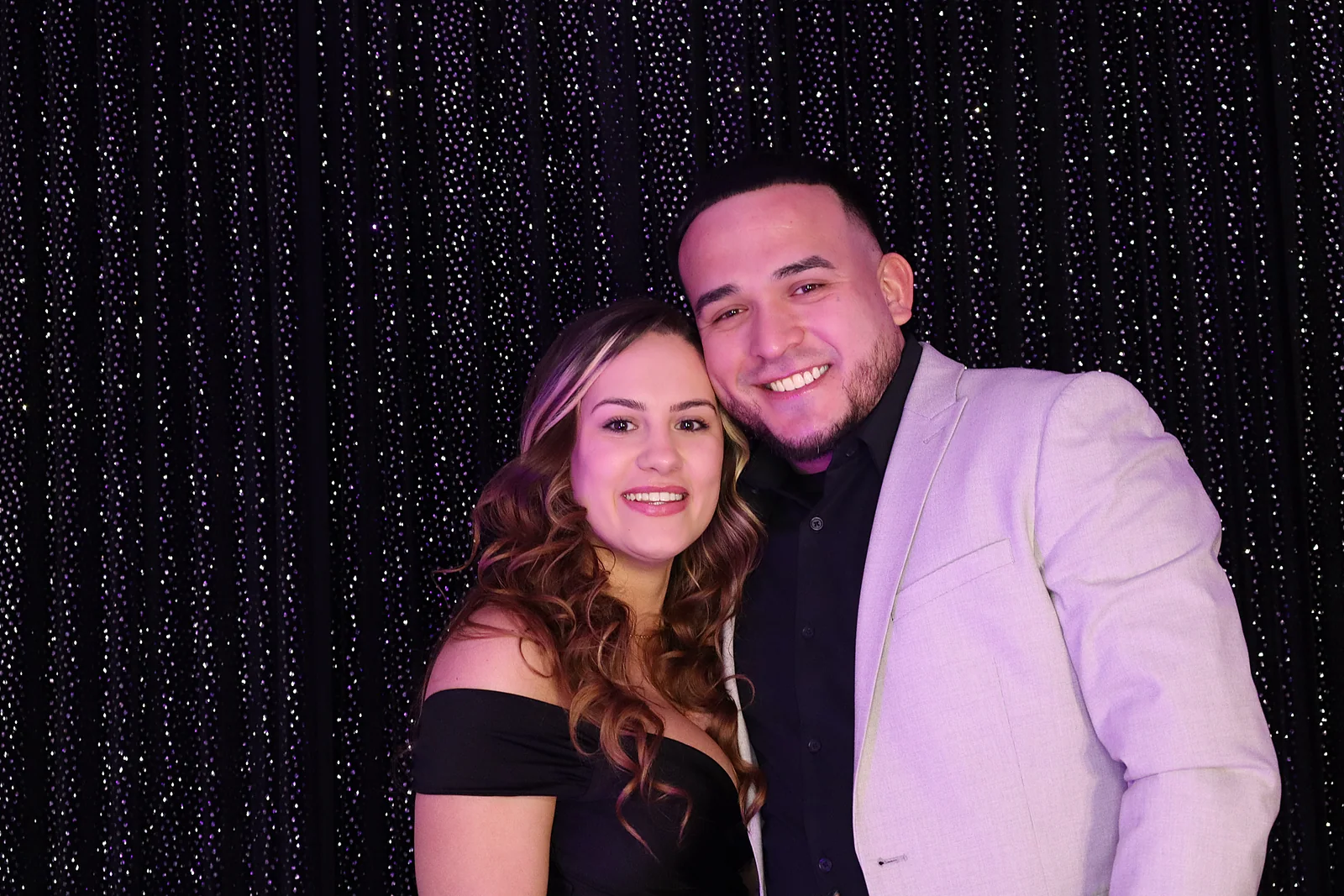 Couple photographed against a black shimmer backdrop at a quinceañera by Images & Creations
