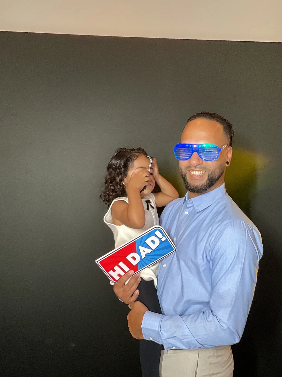Father and daughter having fun with photo booth props at Rosa’s 50th birthday